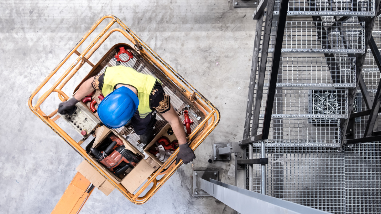 Construction worker in a lift.