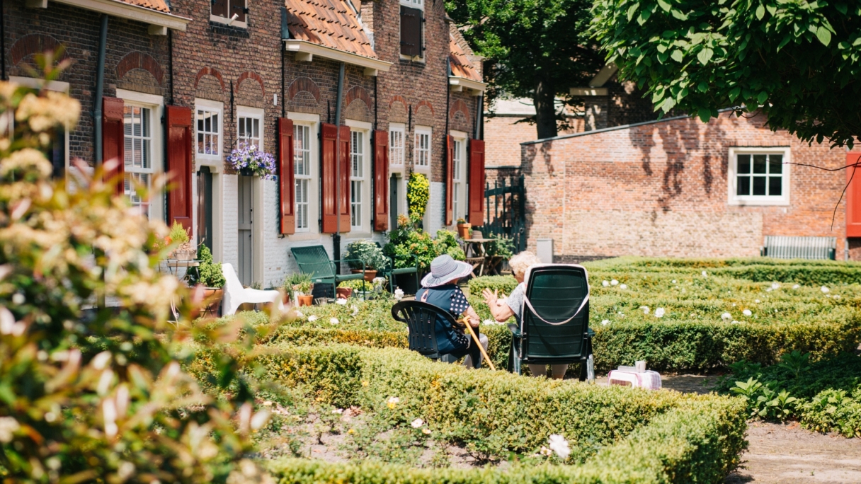 Two elderly women laughing in the garden