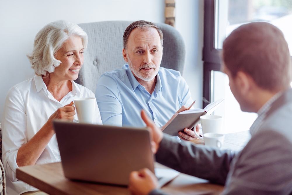 couple talking to an advisor who is showing them something on his laptop